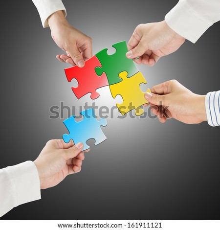 Team work concept, Hands hold puzzles connect each other with gray background