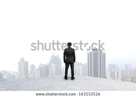 businessman standing on concrete floor and gazing at city