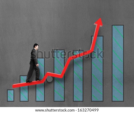 Businessman walking on growth red arrow with chart in concrete wall background