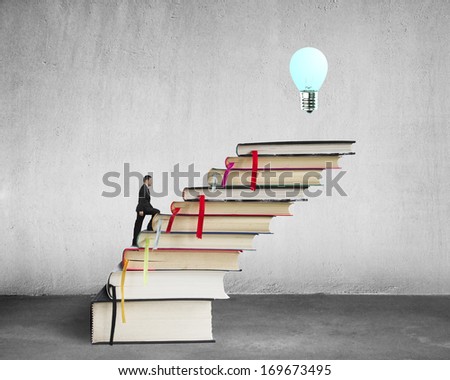 Businessman climbing on stack of books with growing bulb in concrete background