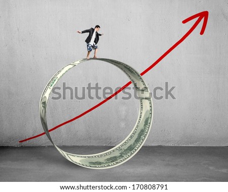 Businessman surfing on money circle with growing red arrow concrete background