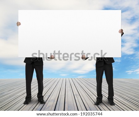 Men standing on wooden floor and lifting board sky background
