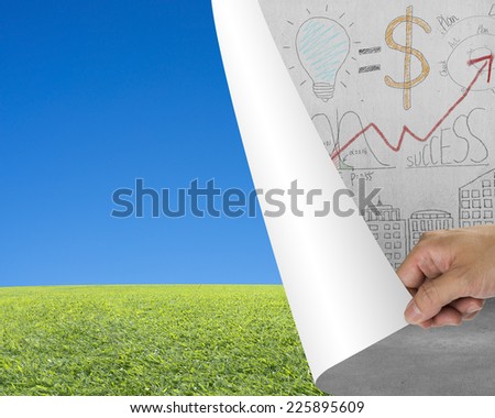 Hand turning business doodles chart page revealing nature sky meadow, free time concept