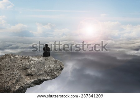 businessman thinking and sitting on cliff with natural sky daylight cloudscape background