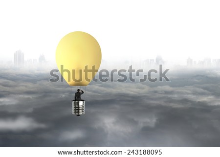 Businessman in brightly yellow lamp hot air balloon flying over gray city sky cloudscape background