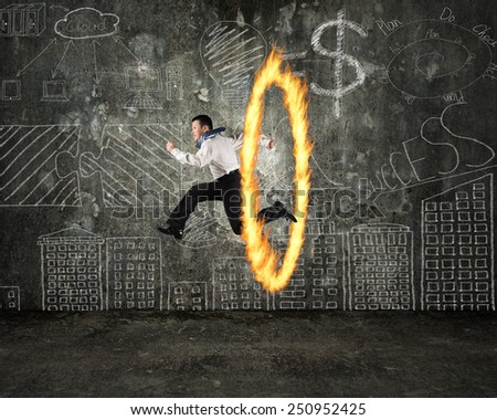 Man jumping through fire hoop with doodles wall background