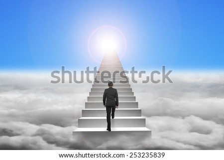 Businessman climbing the concrete stairs with blue sky sunlight cloudscape background