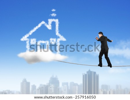 Businessman walking and balancing on rope toward house shape cloud with skyscraper background