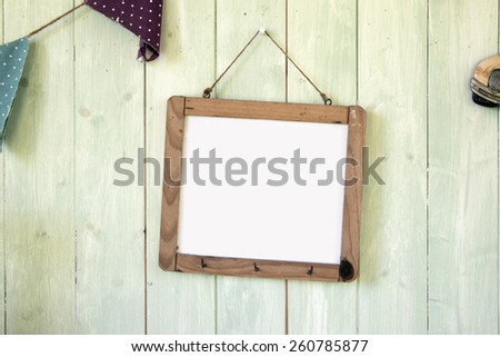 White message board hanging on retro green wooden wall background