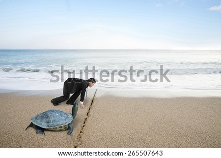 Businessman and turtle are ready to race on sand beach with natural sea background. Turtle race competing metaphor concept.