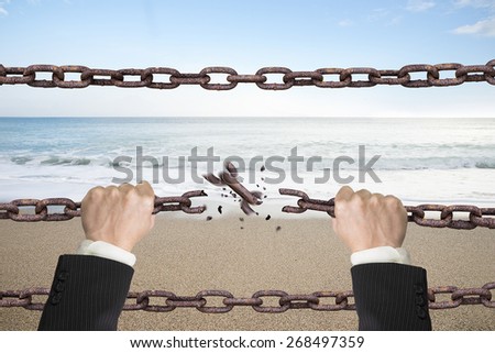 Rusty iron chains broken off by hands with natural sky sea background