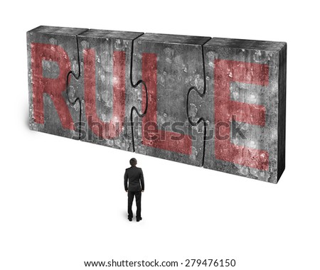 Man facing red rule word on four huge concrete puzzles connected together, isolated on white background