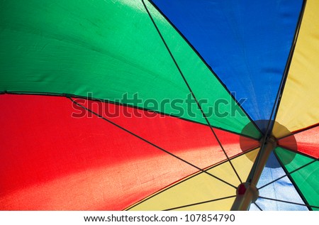 fragment of an colorful umbrella in sunny day