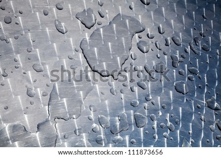 Texture of water drops on shining metal table surface with scratches and circular milling