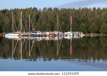 Yachts and pleasure boats moored in small European marina. Imatra town, Saimaa lake, Finland