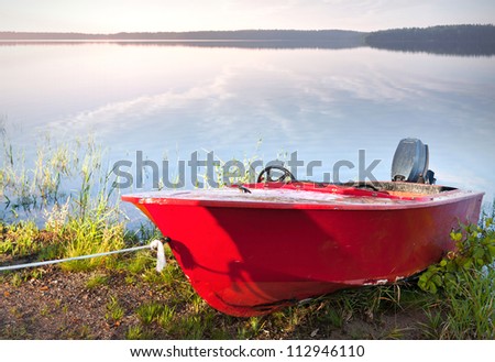 Red motorboat moored on the coast of Saimaa lake, Finland