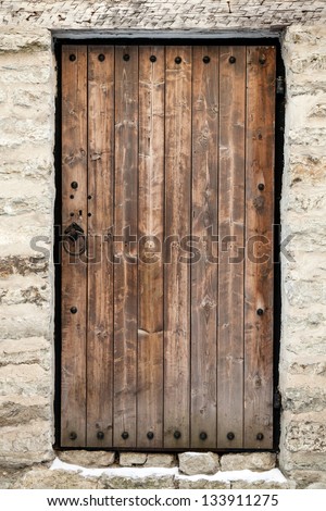 Ancient wooden door in old stone castle wall. Tallinn, Estonia