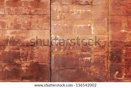 Red rusted metal wall texture with welds