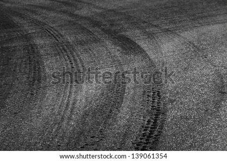 Dangerous turn. Abstract road background with tires tracks on dark asphalt