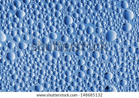 Abstract blue macro background with water drops on glass