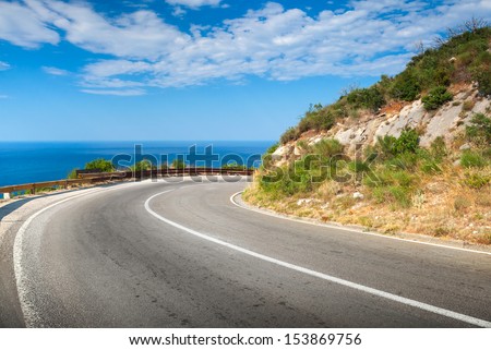 Turn Of Mountain Asphalt Road With Blue Sky And Sea On A Background