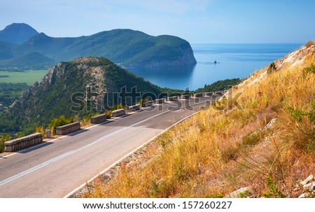 Summer mountain road with blue sky and sea on a background. Adriatic sea coast, Montenegro