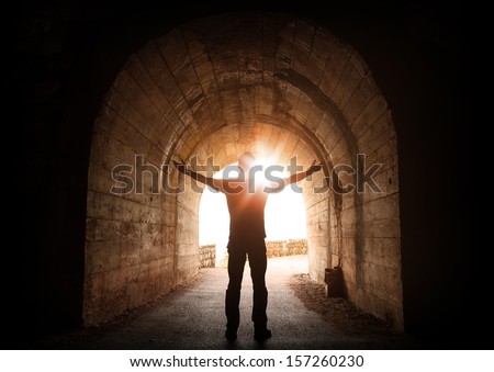 Man Stands Inside Of Old Dark Tunnel With Shining Sun In The End