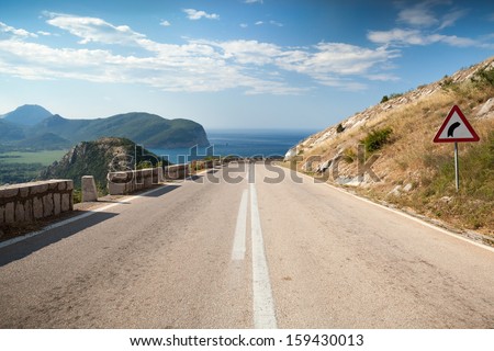 Dividing line and right turn sign on the coastal mountain highway in Montenegro