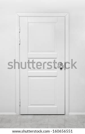 Classical closed wooden door in white office wall