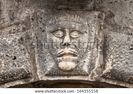 Bas-relief with man\'s face on ancient house facade in Perast town, Montenegro