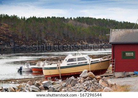 Small motor boats stand on the coast in Norway