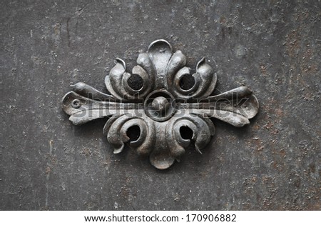 Ancient forged floral decoration element on black door