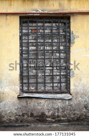 Old yellow building facade with locked window