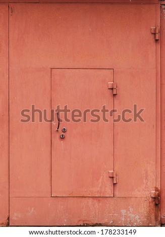 Red metal garage wall with locked door. Background texture