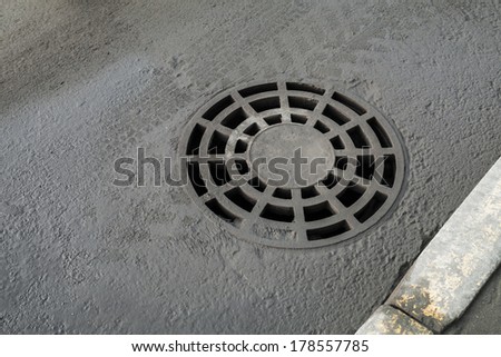 Round drainage sewer manhole cover on urban asphalt road
