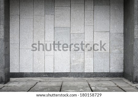 Empty urban interior with stone tiling on wall and concrete floor pavement