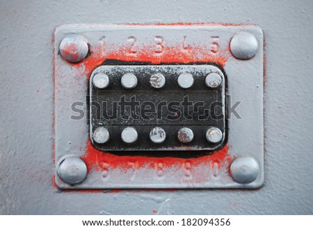 Old code lock with buttons on gray metal door