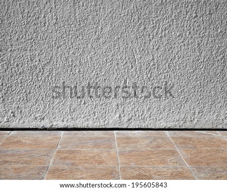 Abstract interior background with rough stucco wall and tiling floor