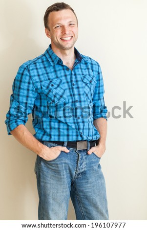 Young positive Caucasian man in casual shirt, studio portrait