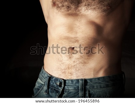 Flat sporty male belly. Close up photo on dark background