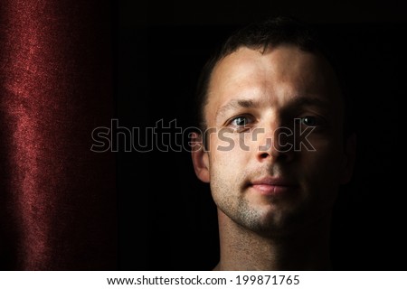 Young Caucasian man close up portrait with curtain
