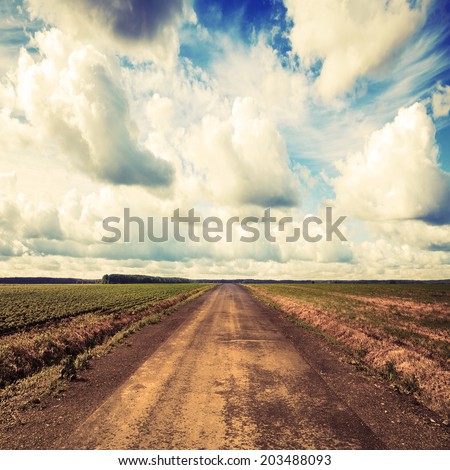 Empty country road perspective with dramatic cloudy sky. Instagram toned effect