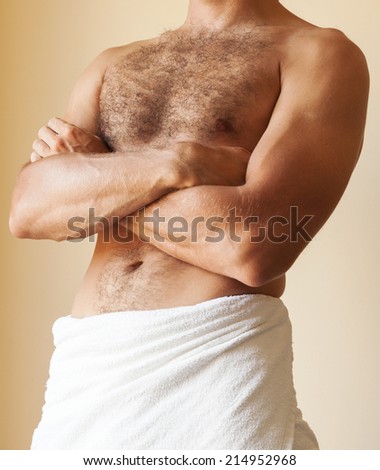 Strong young Caucasian man torso with towel