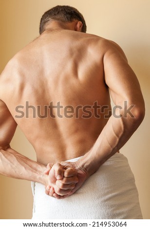 Back of Strong young Caucasian man with white towel