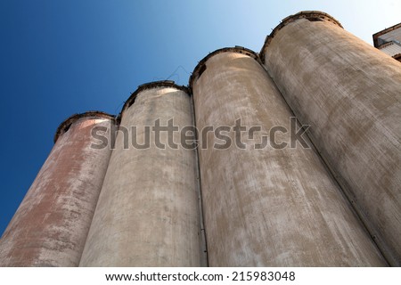 Row of grain silos under deep blue sky