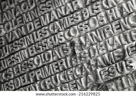 BARCELONA, SPAIN - AUGUST 27, 2014: Words from the Bible in various languages printed on the entrance door of La Sagrada Familia - the impressive cathedral designed by Antonio Gaudi
