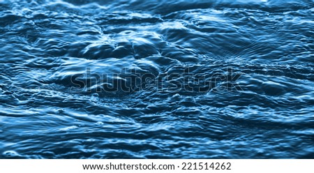 Dark blue flowing river water surface, background photo texture