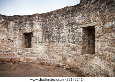 Round ruined interior with empty windows of old stone fort tower. Koporye Fortress, Leningrad Oblast, Russia