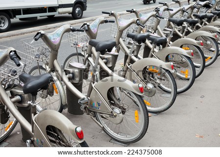 PARIS, FRANCE - AUGUST 07, 2014: Row of gray city public bicycles for rent standing on the parking lot
