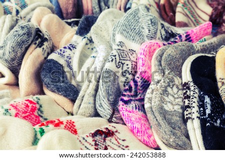 Many knitted woolen socks on the counter. Vintage toned photo with instagram filter effect